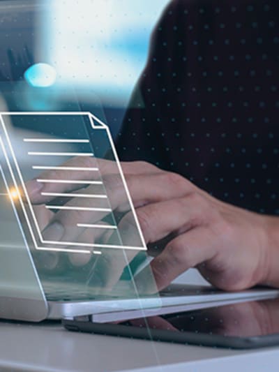 Person works on laptop with digital iconography overlayed.